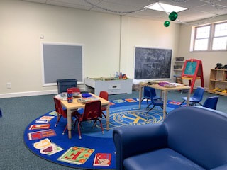 Collinsville Illinois Library kids room with a chalkboard, a couch, and tables.
