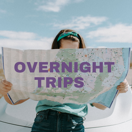 Picture of woman sitting on car and looking at map with the words overnight trip
