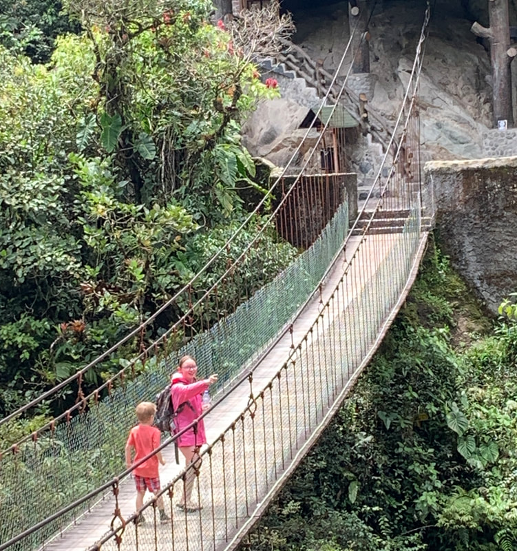 Girl and Boy on rope bridge in mountains in Banos, Ecuador.