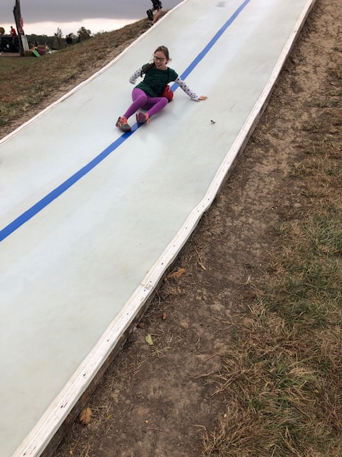 girl sliding down hill at Boonies Farm in Worden, IL