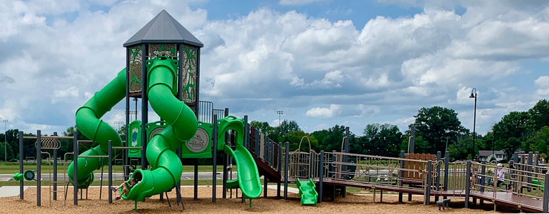 Two story playground with ramps to first story and green tube slides at Glazebrook Park in Alton, IL