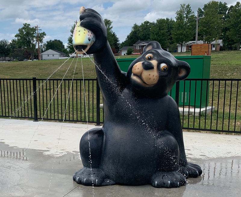 Bear holding fish and spraying out water at Glazebrook splash pad in Alton, IL