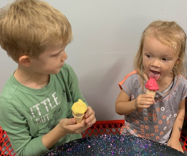 Little girl and boy eating mango and pommegranate ice cream at Mac's Family Fun Time in Highland IL.