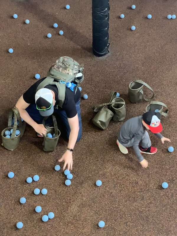 Man and boy collecting blue balls in ammo bags in Silver Dollar City in Branson, IL.