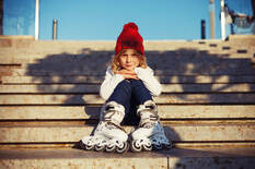 Girl wearing skates and sitting on stairs