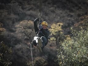 A woman enjoying the new experience of zip lining.