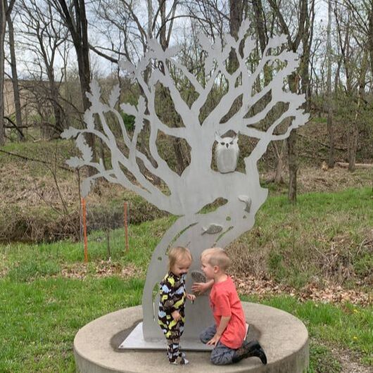two kids standing by metal tree with owl in it. Queeny Park (STL)
