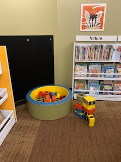 Roxana Illinois Library kids room with books organized by subject and blocks for building towers.