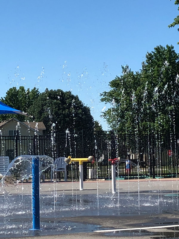 Splash pad with waist high sprinklers and black fence in Bethalto IL