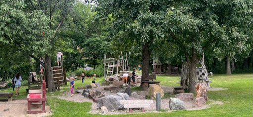 playground with mud kitchen on left side, climbing structures, and large trees at The Nature Institute or John M Olin Nature Preserve in Godfrey IL. Parks in Godfrey IL